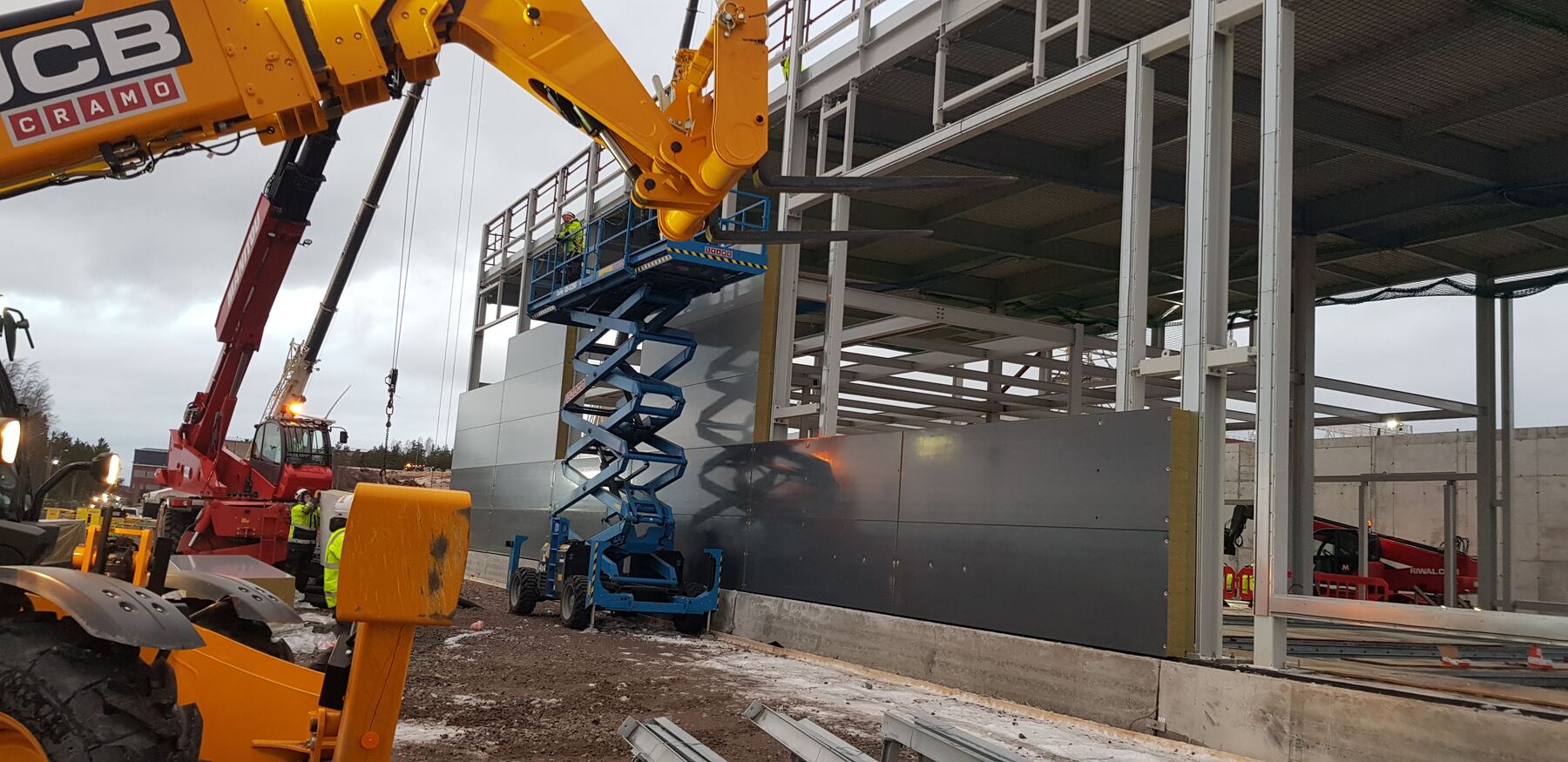 Installing insulated cladding panels with a telehandler and access platform